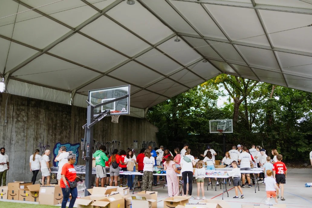Volunteers serving together under a pavilion at a past Grace Church Serve Day